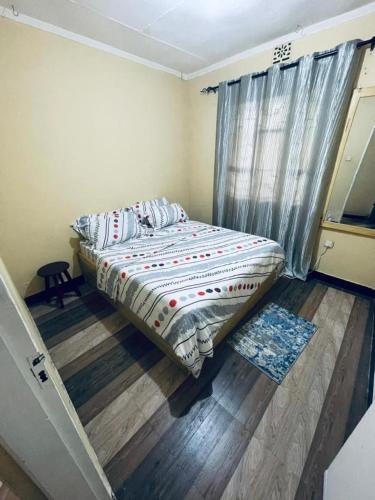 ein Schlafzimmer mit einem Bett in einem Zimmer in der Unterkunft Cozy House, Quiet Area Kimandolu in Arusha