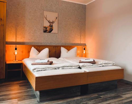 a bedroom with a bed with a deer picture on the wall at Pension Sonnenschein in Jahnsdorf