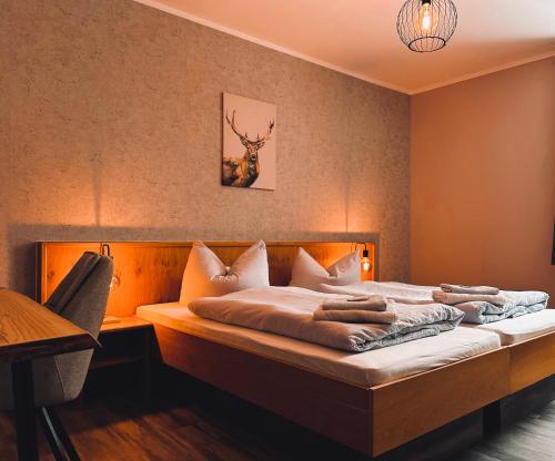 a bedroom with a bed with a deer on the wall at Pension Sonnenschein in Jahnsdorf