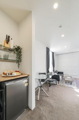 a kitchen with a counter and a living room at Dunedin Central Luxe Pad in Dunedin