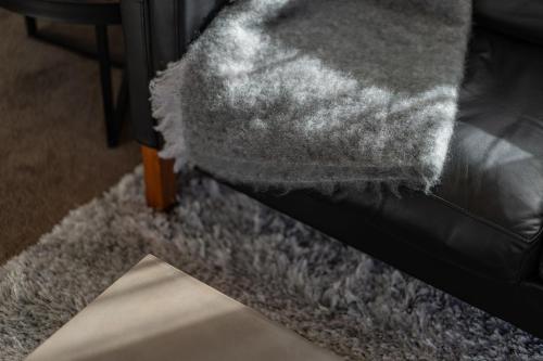 a black couch with a grey blanket on it at Dunedin Central Luxe Pad in Dunedin