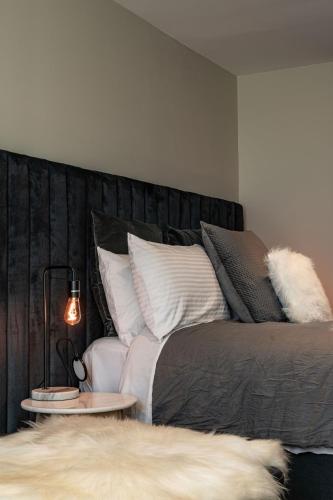 a bedroom with a bed with white pillows at Dunedin Central Luxe Pad in Dunedin