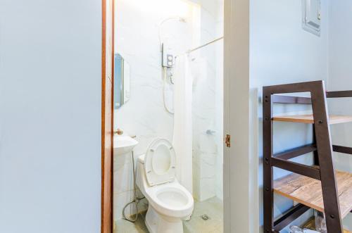 uma casa de banho com um WC, um chuveiro e uma escada. em Casa Alberto em Calapan