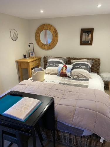 a bedroom with a bed with a table and a mirror at Chambre Folle Avoine in Brié-et-Angonnes