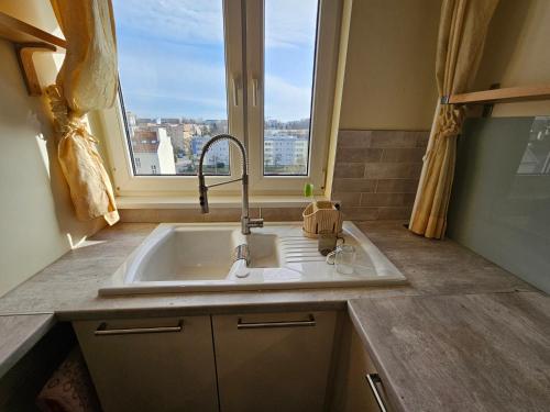 a kitchen with a sink and a window with a view at First Green Żoliborz Apartment 9 in Warsaw