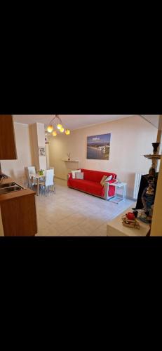 een woonkamer met een rode bank en een tafel bij Appartamento estivo in Vieste
