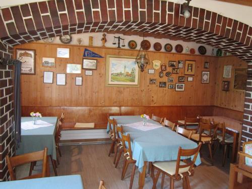 Gasthaus Hingerl في Obing: غرفة طعام مع طاولات وكراسي وصور على الجدران