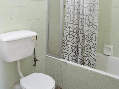 een badkamer met een toilet en een douchegordijn bij Cutty Sark Lodge in Kariba