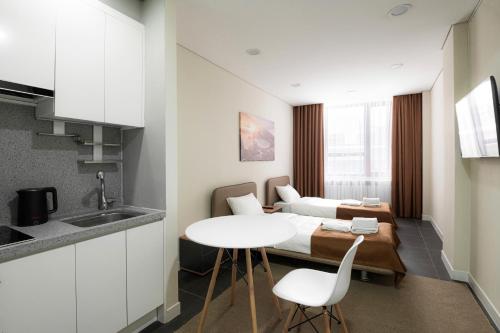 a room with a bed and a table and chairs at HIGHVIL APARTAMENTS in Astana