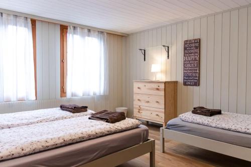 a room with two beds and a dresser in a room at Lakeview Family Apartment in Ringgenberg