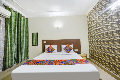 a bedroom with a large white bed with colorful pillows at FabExpress Smart Stay in New Delhi