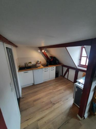 Il comprend une cuisine mansardée avec des placards blancs et du parquet. dans l'établissement La Compagnie De La Ville, à Honfleur