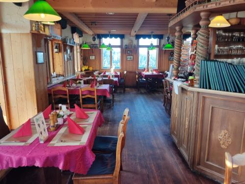 a restaurant with tables and chairs in a room at Berggasthaus & Pension Schöne Aussicht in Klingenthal