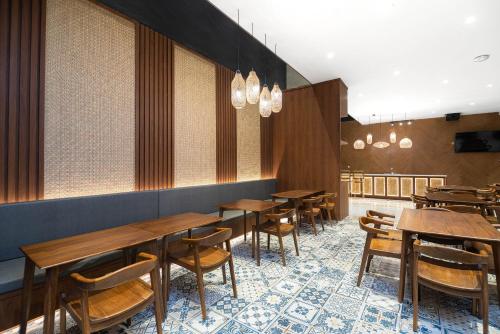 a dining room with wooden tables and chairs at ARTOTEL Cabin Bromo in Bromo