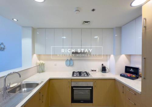 a kitchen with a sink and a stove top oven at Superb 1BR at Burj Vista In Downtown Dubai in Dubai