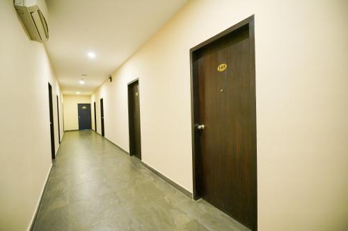 a hallway with a brown door and a hallwayngth at Mookkannoor Tourist Home in Angamali