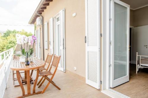 a dining room with a table and chairs on a balcony at Casa Aydée in Bergamo