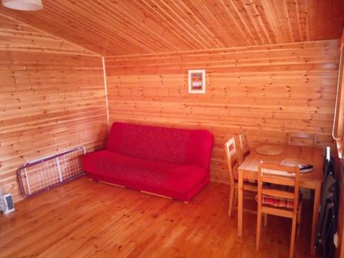 Wylatkowo的住宿－Apartament Wylatkowo - Powidz，一张红色的沙发,位于带桌子的房间