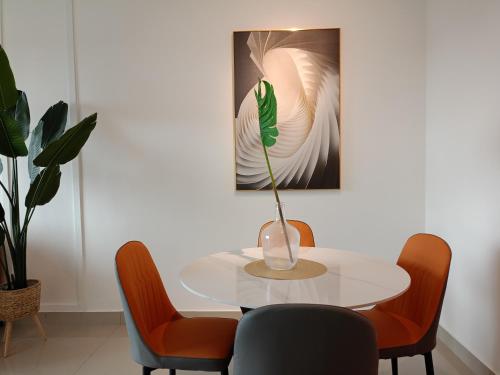 una mesa blanca con sillas y un jarrón encima en Bayu Temiang Luxury Design 7~8 Pax en Seremban