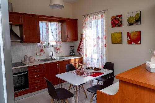 a kitchen with a table and chairs in a kitchen at Robellini Palm in Kounoupidhianá