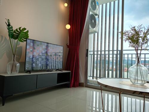 ein Wohnzimmer mit einem TV und einem großen Fenster in der Unterkunft Bayu Temiang Luxury Design 7~8 Pax in Seremban