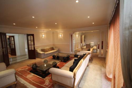 een grote woonkamer met banken en een tafel bij High Gable House -Four Bedrooms in Hillingdon