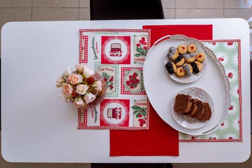 a table with a plate of cookies and a plate of cake at Robellini Palm in Kounoupidhianá
