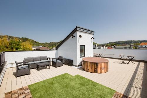 a patio with a table and chairs on a roof at 104号室 海の見えるシェアハウスRoopt Hayama Collective Houseの一室 in Hayama