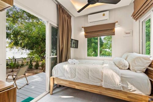 a bedroom with a large bed and a balcony at Brand New Beachfront & Secluded Tiny House in Koh Samui 