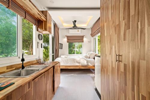 a kitchen with a sink and a bed in a room at Brand New Beachfront & Secluded Tiny House in Koh Samui 