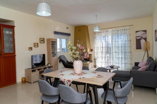 a living room with a table and chairs at Robellini Palm in Kounoupidhianá