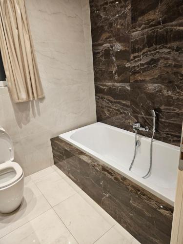 uma casa de banho com um WC e uma banheira em Luxury Waterfront Apartment em Mellieħa