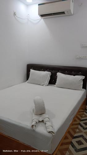 una cama con un animal de peluche sentado en ella en Hotel king palace madhubani, en Madhubani
