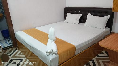 uma cama com dois pares de sapatos em Hotel king palace madhubani em Madhubani