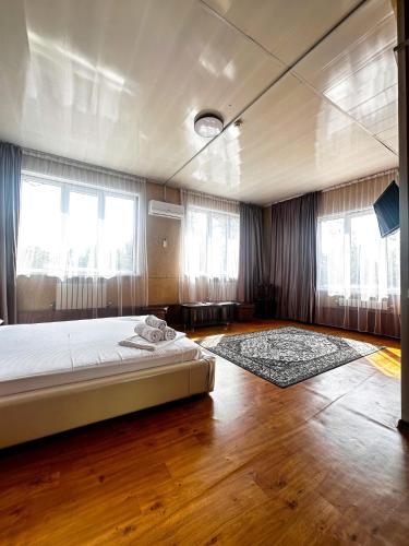 1 dormitorio con 1 cama y 2 ventanas en Гостиничный комплекс Bal-Meyir en Almaty