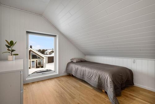 a bedroom with a bed and a large window at Moderne enebolig in Røros