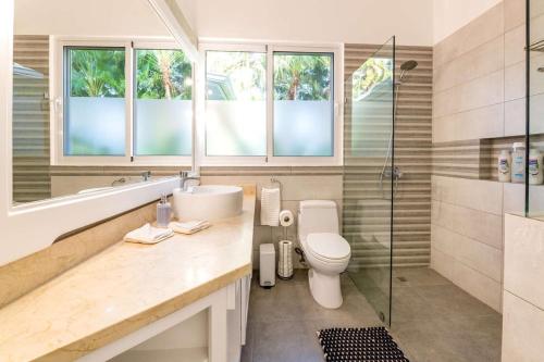 ein Bad mit einem WC, einem Waschbecken und einer Dusche in der Unterkunft Spacious 4 BR near Golfing Neighborhood in La Romana