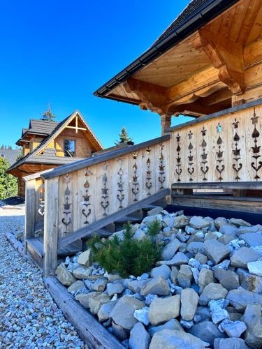 a wooden house with a bridge over a rock garden at Chaty Misiagi in Poronin