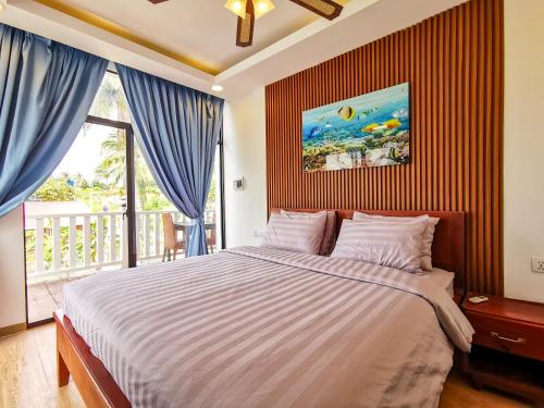 um quarto com uma cama grande e uma varanda em The White Palace Koh Sdach em Kaoh Sdach