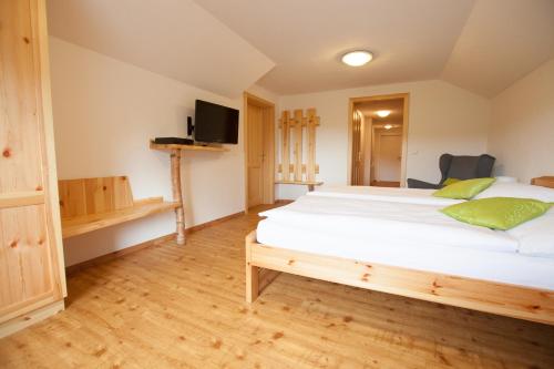 a bedroom with a large white bed and a tv at Beim Einfalt B&B in Grossgerungs