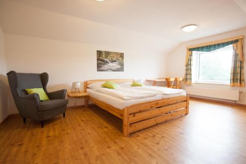 a bedroom with a bed and a chair at Beim Einfalt B&B in Grossgerungs