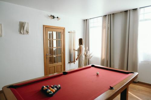 a woman standing in a room with a pool table at Maison Patisson in Kasterlee