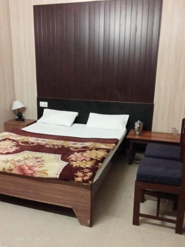 a bedroom with a bed and a wooden headboard at Hotel Savera, agra in Agra
