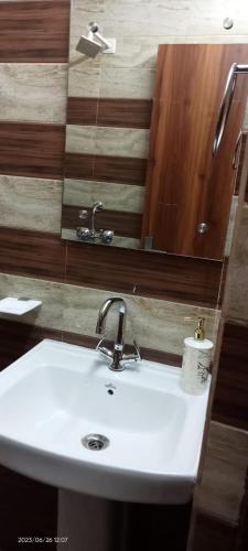 a bathroom with a white sink and a mirror at Hotel Savera, agra in Agra