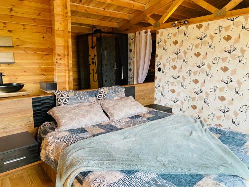 a bedroom with a bed in a wooden cabin at CHALET EN BOIS PRIVATIF ST POURCAIN SUR SIOULE in Bransat