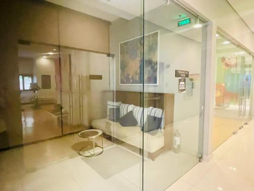 een kamer met een glazen wand met een bank erin bij Signa Designer Residences in Manilla