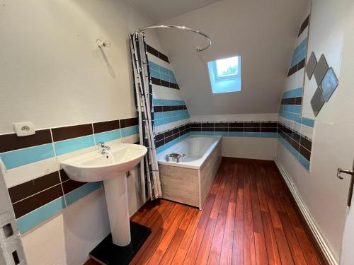 La salle de bains est pourvue d'un lavabo et d'une baignoire. dans l'établissement Superbe Maison de maître 10 chambres 300 m2 Caen, à Bretteville-sur-Odon