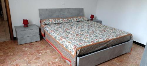 a bed in a bedroom with two nightstands and two red candles at Luna Rossa da Nadia in Levanto