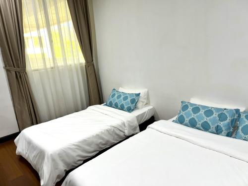 two beds in a small room with a window at Seascape Karambunai Home - Amazing sea front view! in Kota Kinabalu
