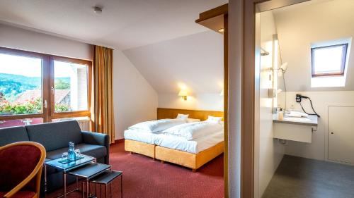 Habitación de hotel con cama y sofá en Hotel Restaurant Lamm Hebsack, en Remshalden